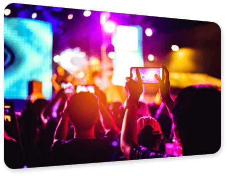 A group of youngsters using their mobile phones to record a live concert